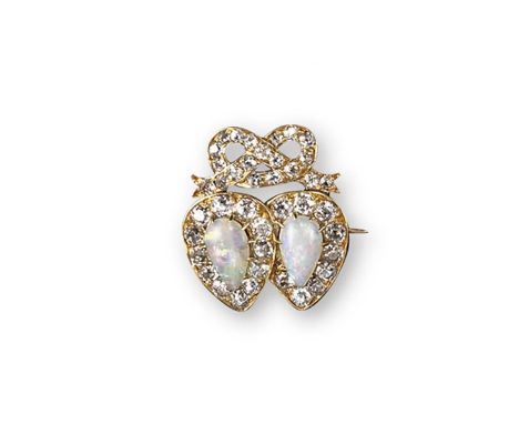 An Edwardian romantic brooch set with opals and diamonds. The stylised intertwined hearts each centred with a pear-shaped opa
