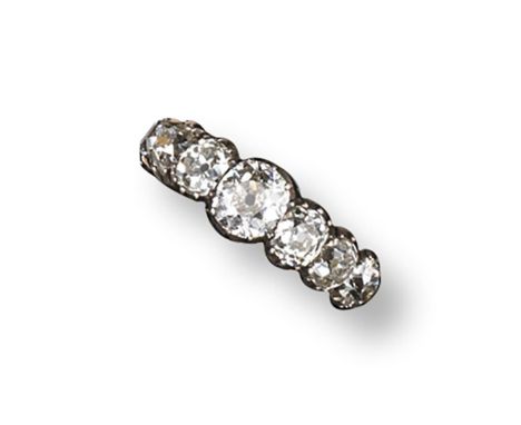 An early 19th century diamond-set seven stone ring, the seven graduated cushion-shaped diamonds are set in silver and gold cu