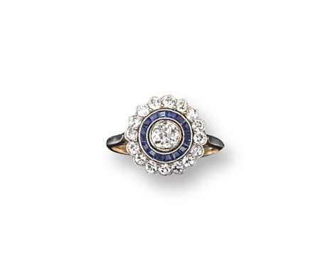 An early 20th century sapphire and diamond cluster ring, the central old cushion-cut diamond is set within a surround of cali