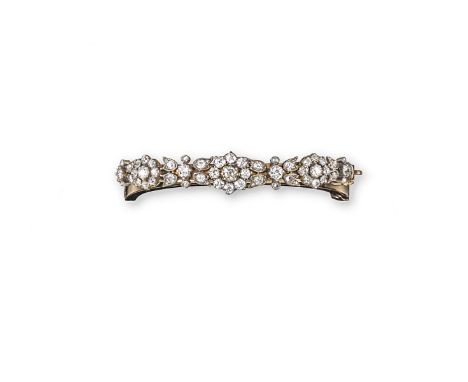 A diamond-set gold hinged bangle, mounted with clusters of old cushion-shaped diamonds and diamond set leaves in silver and g