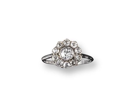 A diamond cluster ring, the old circular-cut diamond is set within a surround of smaller diamonds in platinum. Size S.