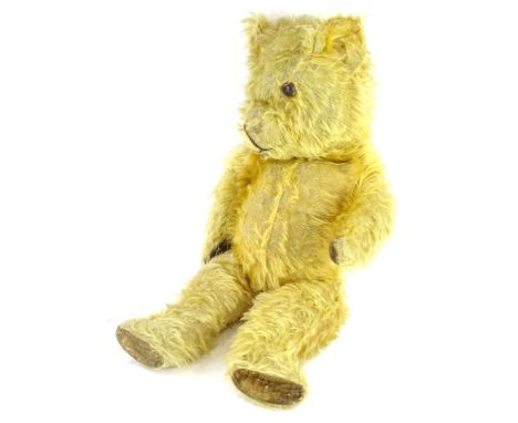 A vintage teddy bear, with velvet pads (AF), label to reverse stating Made in England, 53cm long