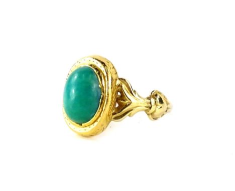 A turquoise set dress ring, with oval cut stone, in a gold hatched rub over setting, with V splayed scroll shoulders, yellow 