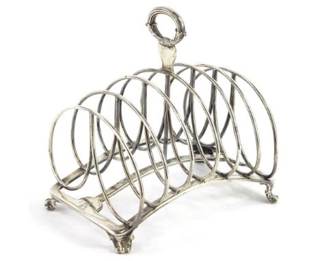 A George IV silver six division toast rack, with reeded and scroll cast handle, concave base and scroll feet, London 1829, by