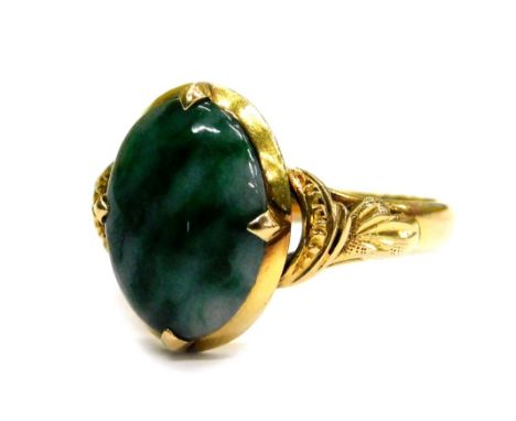 A modern jade set dress ring, the oval jade with pale and dark green striations, in a four claw setting, in a yellow metal fr