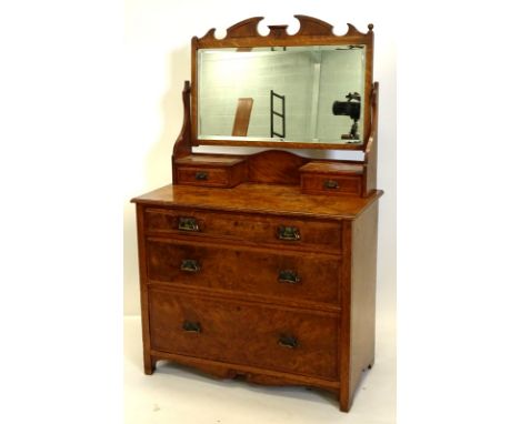 A late 19thC oak and burr oak dressing table, the rectangular mirrored plate with a shaped crest and bevelled edge on shaped 