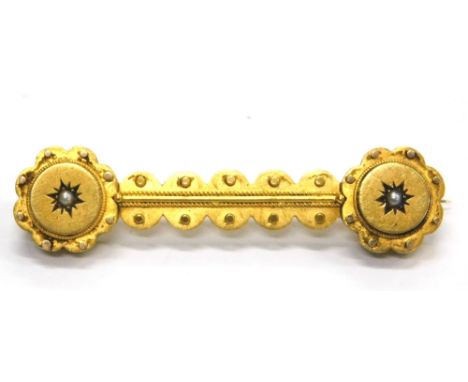 A Victorian bar brooch, with reeded and dot design, set with a single seed pearl at each end, yellow metal, unmarked, 5cm wid