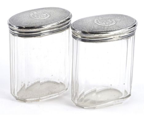 A pair of Victorian facetted oval cut glass dressing table jars, each with an engine turned lid with monogram, London 1871, s