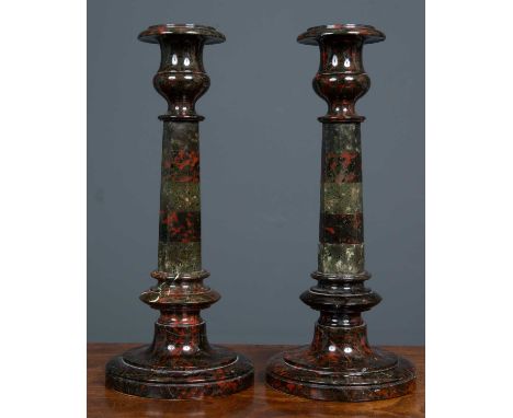 A pair of serpentine marble candlesticks each formed as an octagonal column on a turned base, 13cm diameter at the base x 30c
