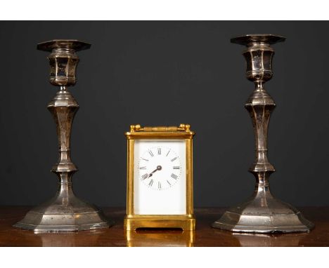 A pair of silver candlesticks, Sheffield, 20cm high together with a brass carriage clock, the enamelled single dial with roma