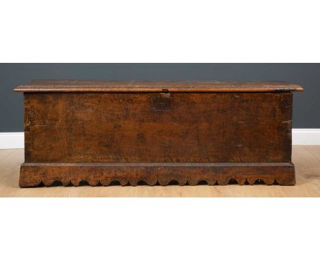 A 17th century six plank oak coffer, with lock plate on low bracket feet with carved apron, 157cm wide x 42cm deep x 55cm hig