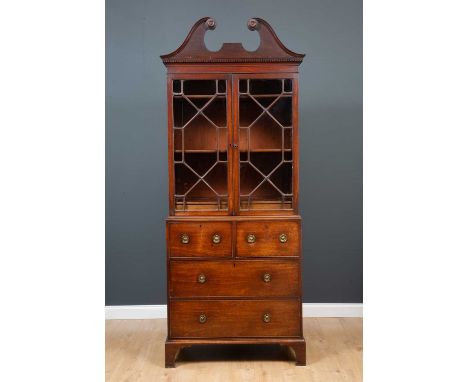 A George III mahogany cabinet on chest with broken scroll pediment, pair of glazed doors over internal shelf and two short ov