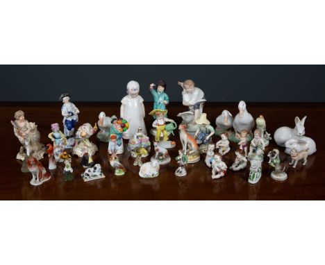 A collection of antique and later porcelain figurines to include a four piece cherub band, a Herend porcelain parrot 7.5cm hi
