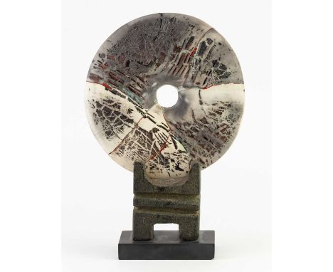 † PETER HAYES (born 1946); a fractured smoky raku disc mounted on canal clay and slate base, incised signature dated 2001, he