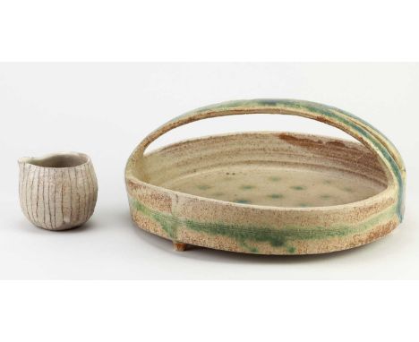 YO THOM (born 1973); a stoneware basket on tripod feet covered in mottled beige glaze with turquoise/green decoration, impres