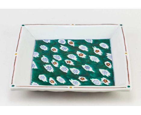 † RUSSELL COATES (born 1949); a square porcelain dish covered in white glaze with Japanese style enamel decoration to the wel