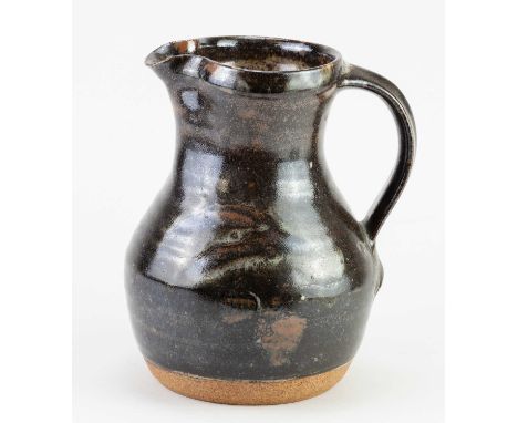 † GEOFFREY WHITING (1919-1988) for Avoncroft Pottery; a stoneware jug covered in tenmoku breaking to kaki glaze, impressed GW