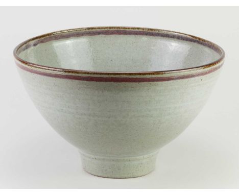 † DAVID LLOYD JONES (1928-1994); a large deep stoneware bowl covered in speckled grey glaze with iron and copper red rim and 