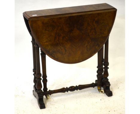 A Victorian burr walnut Sutherland table, the oval drop leaf top raised on a turned gateleg frame to brass mounted ceramic ca