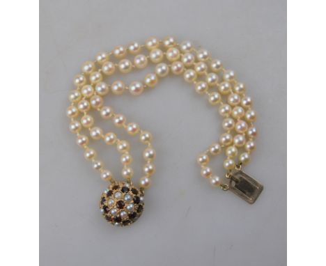 A triple row uniform cultured pearl bracelet on garnet and cultured pearl domed snap Condition Report Two pearls on snap in p