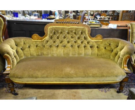 A Victorian inlaid walnut show-framed button backed salon sofa with shaped corner, raised on turned front legs to castors, 18