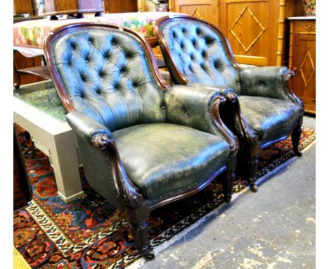 A pair of Victorian mahogany framed button backed leather salon armchairs raised on turned tapering and gadrooned front legs 