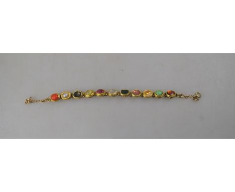 An Indian gold bracelet set with coral, pearl, chrysoberyl cat's eye, ruby, diamond, tourmaline, citrine, turquoise etc, most
