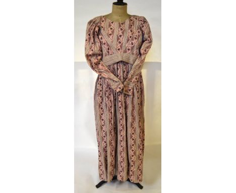 An early 19th century cotton dress with printed stylised floral and foliate sprays on dusky pink ground with co-ordinated bel