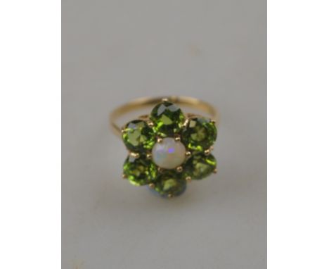 A peridot cluster ring with a cabochon opal in centre, 9ct yellow gold claw setting, approx 2 cm diam overall Condition Repor