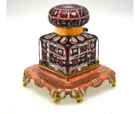A 19th century Bohemian ruby flash glass square ink bottle, having hinged metal mounts and separate copper and brass stand, 1