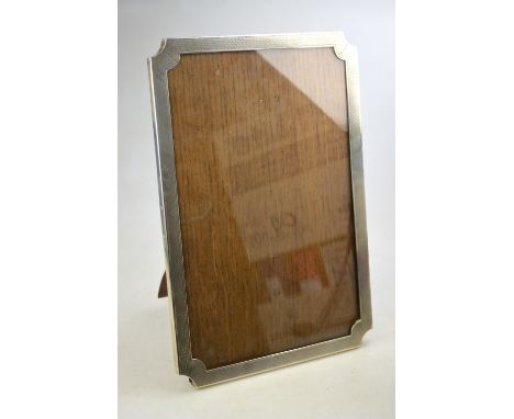 A silver easel photograph frame with engine-turned decoration and oak back, Saunders & Mackenzie, Birmingham 1924, 36 x 24 cm