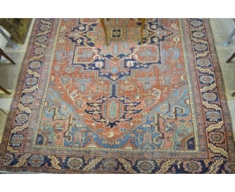 An antique Persian Heriz carpet, the geometric centre medallion design on mid-red ground, 3.75 x 2.75 m Condition Report Over