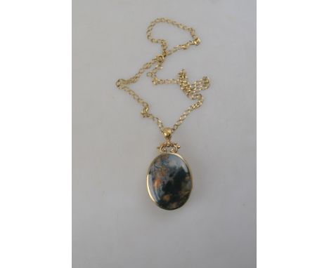 A moss agate and jasper oval pendant in 9ct collet setting on 9ct chain