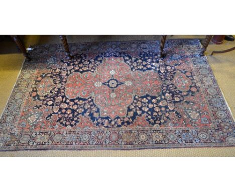 An antique Persian Feraghan Sarouk rug, 1st quarter 20th century, the floral design centred with a medallion on soft red and 