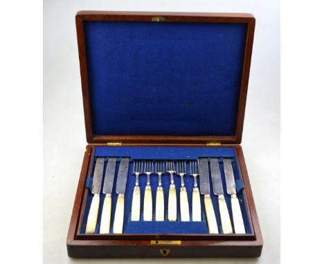 A mahogany cased set of twelve Georgian silver dessert knives and forks with reeded ferrules and mother-of-pearl handles (one