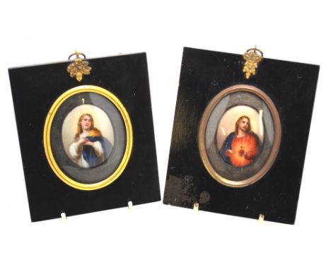 A pair of 19th century oval ceramic miniature plaques, printed and painted with Jesus Christ and the Madonna, in ebonised fra