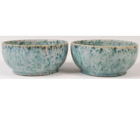 A pair of early 20th Century antique vintage studio art pottery stoneware bowls both having a mottled / speckled semi iridesc
