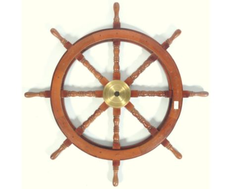 An early 20th Century vintage ships wheel of oak and brass construction having central brass disk with spindle gallery and sh