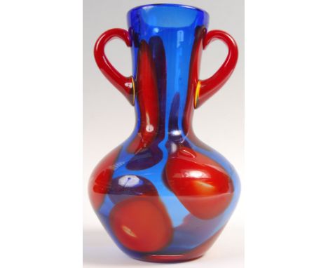 A late 20th Century retro vintage heavy twin handled glass vase having a bulbous and trumpeted blue translucent and red opaqu