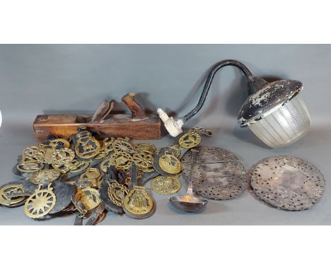 A patinated metal wall lamp with glass shade together with a collection of horse brasses and other items 