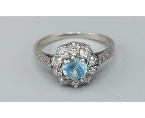 A white gold Diamond and blue Zircon cluster ring, set with a central blue zircon surrounded by diamonds and with diamond sho