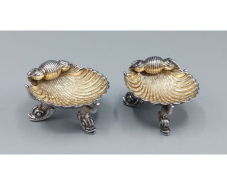 A pair of Victorian silver gilt salts of scallop form, each with three Dolphin feet, Birmingham 1864, maker George Unite 