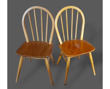 A pair of Ercol blonde ash stick back chairs with panel seats with turned legs 