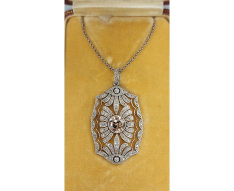 An Art Deco white gold pendant, with a central coloured Diamond, approx. 0.90ct, surrounded by Diamonds with fine link chain,