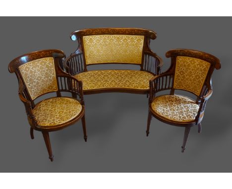 An Edwardian mahogany marquetry inlaid three piece drawing suite comprising two armchairs and a matching sofa 
