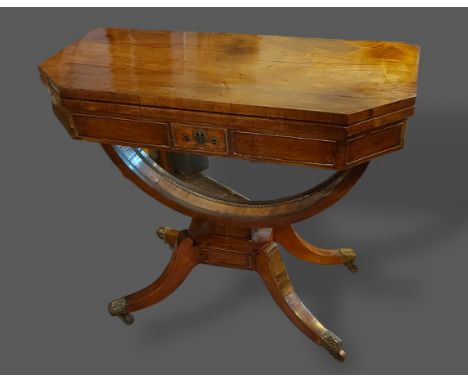 A Regency mahogany and brass inlaid card table, the hinged top above an inlaid frieze above a U stretcher raised upon outswep