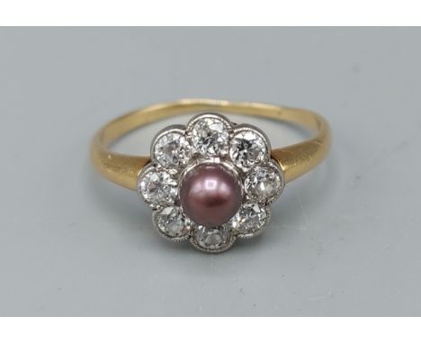 A yellow gold diamond and grey pearl cluster ring, set with central pearl sounded by eight diamonds within a pierced setting,