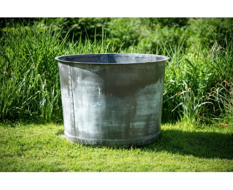 A LARGE PATINATED COPPER AND RIVETED PLANTER CONTEMPORARY With a rollover edge, tapering cylindrical body, pierced for draina
