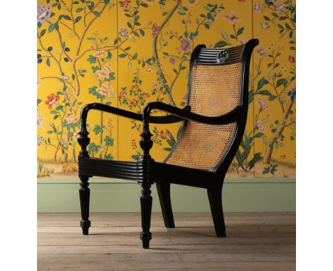 Y A CEYLONESE CARVED EBONY BERGERE ARMCHAIR  PROBABLY GALLE DISTRICT, FIRST HALF 19TH CENTURY 103cm high, 67cm wide, 70cm dee