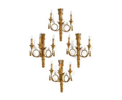A SET OF FOUR CARVED GILTWOOD THREE BRANCH WALL LIGHTS  IN LOUIS XVI STYLE, 20TH CENTURY Each with arrow and quiver backplate
